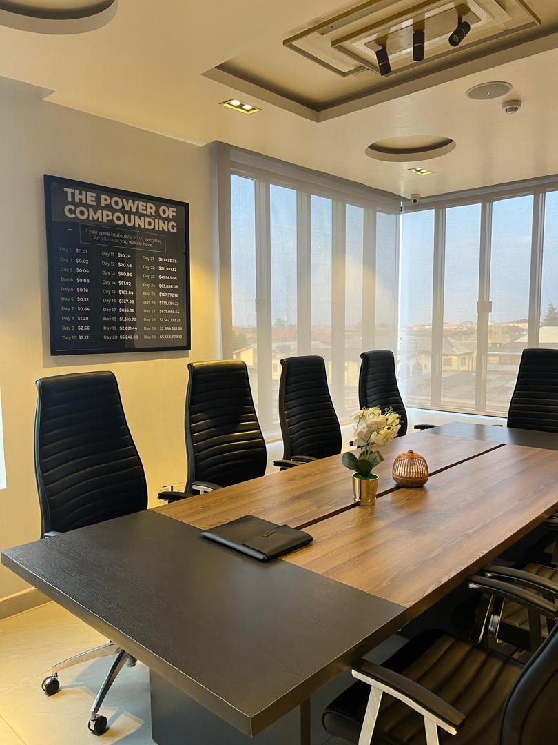 Boardroom with long wood table, executive chairs and floor-to-ceiling windows