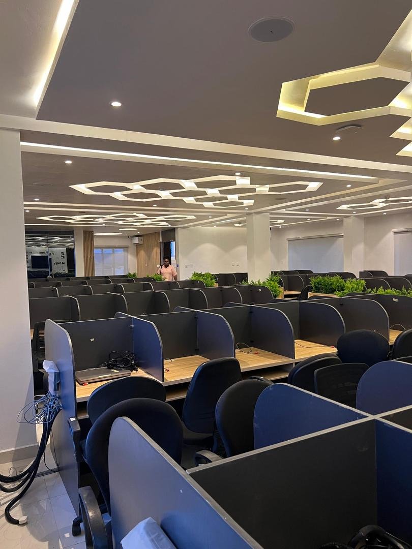 Call-centre workspace with hexagon lighting and tiered seating bays